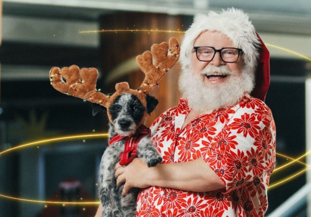Viejito pascuero cargando un perro