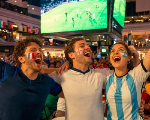 Tres personas viendo un partido de fútbol