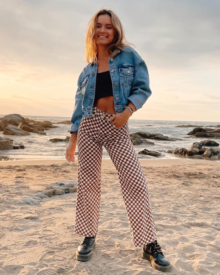 Mujer en la playa usando una chaqueta de jeans y pantalones con rombos