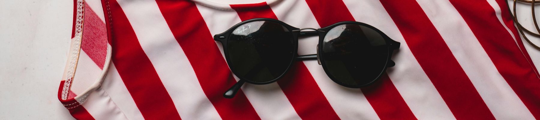 Lentes de sol en toalla roja con blanco