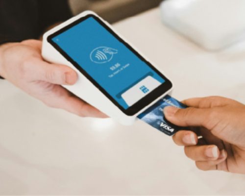 Persona pagando en una máquina con una tarjeta