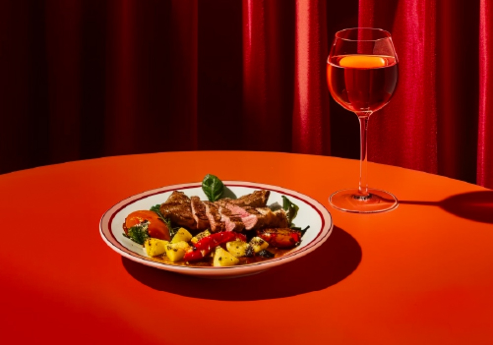 Plato de comida y una copa en un mantel rojo