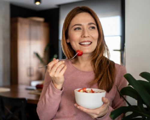 Mujer comiendo un bowl con frutilla
