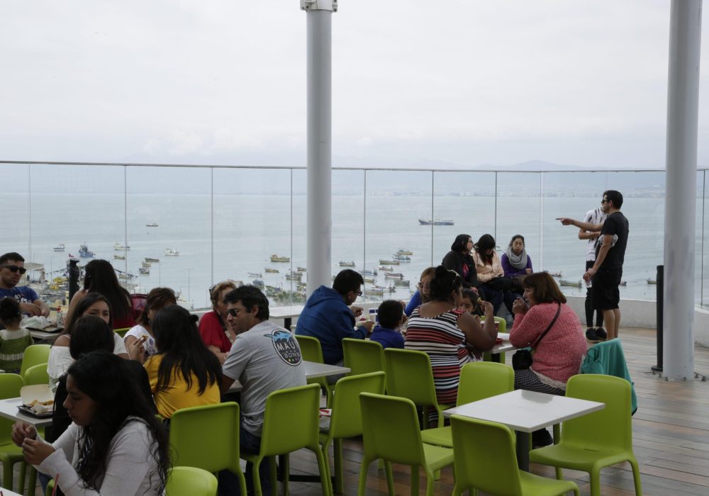 Grupo de personas comiendo en las mesas de la terraza