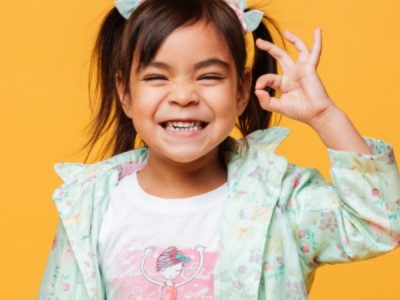 Niña sonriendo con un fondo amarillo