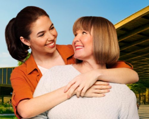 Dos mujeres abrazadas sonriendo